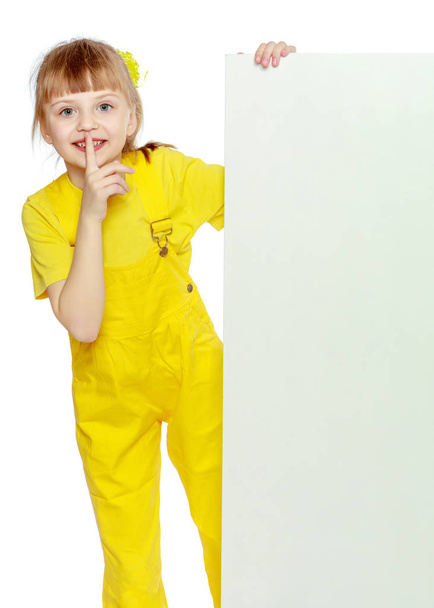 Girl with a short bangs on her head and bright yellow overalls. - Fotoğraf, Görsel