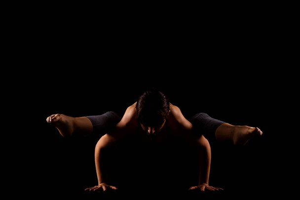 girl in shadows exercising yoga - Foto, imagen