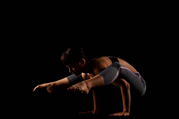 girl in shadows exercising yoga - Fotó, kép