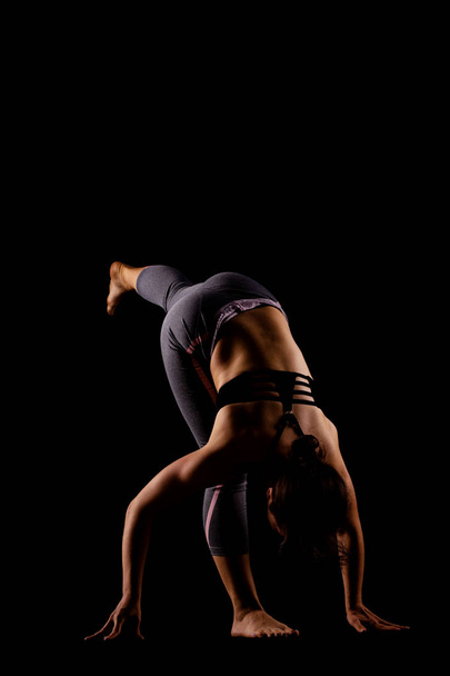 girl in shadows exercising yoga - Фото, зображення