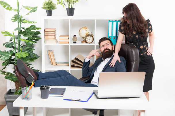 Offer massage. Man bearded hipster boss sit in leather armchair office interior. Boss and secretary girl at workplace. Relations at work. Business people and staff concept. Lazy boss office - Fotografie, Obrázek