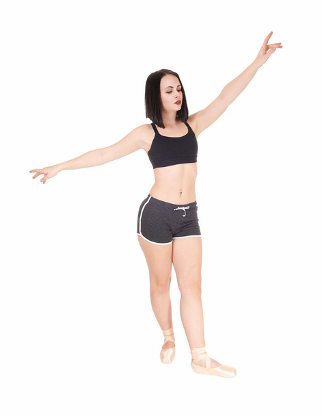 Dancing young woman standing hands raised in shorts - Φωτογραφία, εικόνα