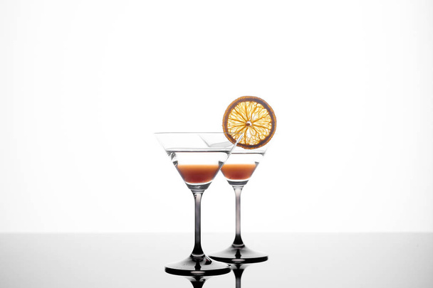 Martini szkła na białym tle z pomarańczowy kromka - Zdjęcie, obraz