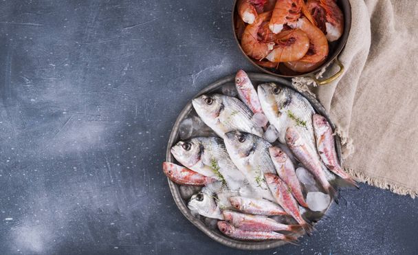 raw fish on a gray stone background. Fresh food for dietetic foo - Фото, изображение