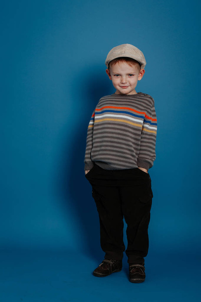 A little boy in a cap is posing and smiling. - Φωτογραφία, εικόνα