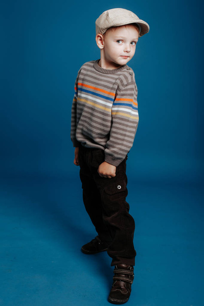 A little boy in a cap is posing and smiling. - Φωτογραφία, εικόνα