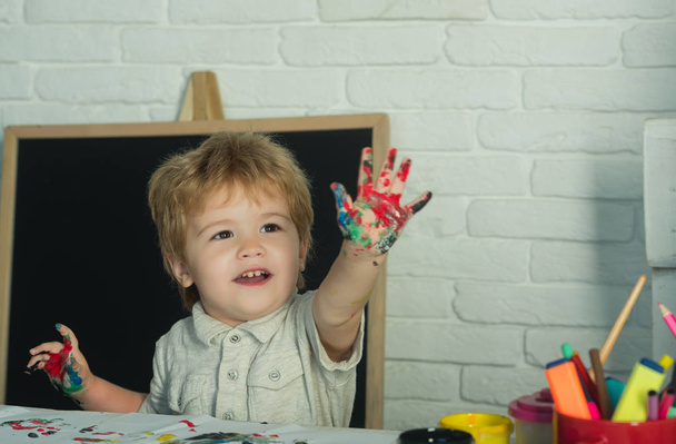Πολύχρωμο παιδί στο χέρι. Χρωματίστε τα δάχτυλα, αγόρι ισοπαλίες με πολύχρωμα παλάμη του τα χέρια και το δείχνει. Εκπαίδευση και ανάπτυξη, τέχνη, σχέδιο. Εναλλακτική εκπαίδευση στο σπίτι χωρίς σχολείο - Φωτογραφία, εικόνα