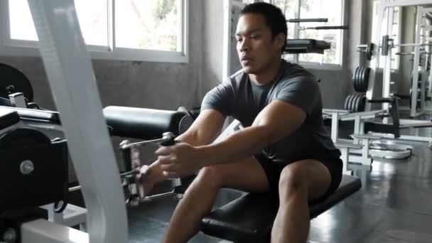 Young Asian man using chest press in gym. Fitness lifestyle. - Materiał filmowy, wideo