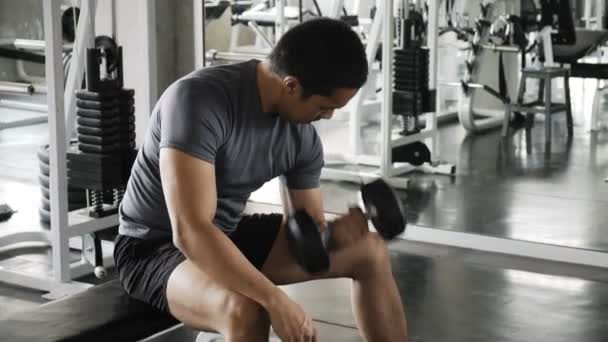 Young asian man lifting dumbbell in gym. Authentic Fitness lifestyle concept. - Video