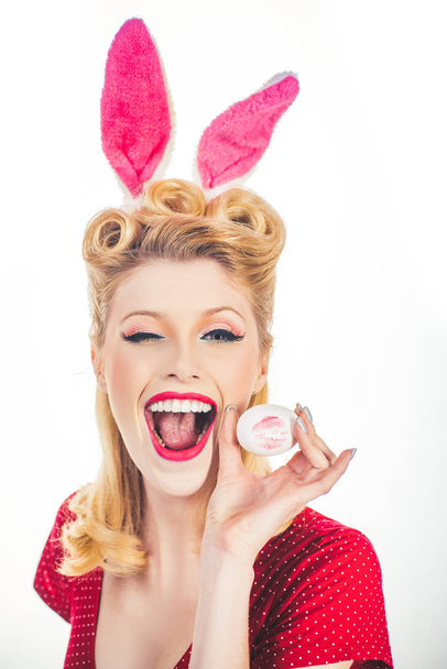 Pin-up Easter. Sexy woman in bunny ears winking. Sweet adorable girl in bunny ears celebrating Easter. Isolated white background. Woman wearing Easter bunny ears and looks very sensually. - Фото, изображение