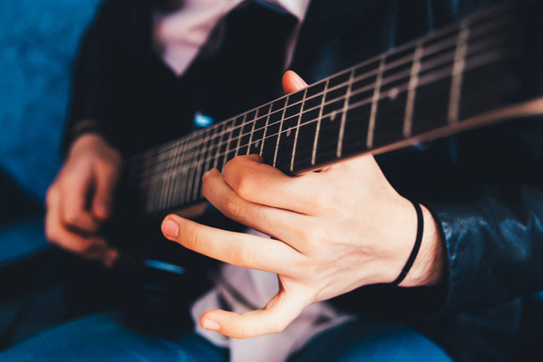 Detail van de vingers van een gitarist spelen een snaar op een uitverkorenen - Foto, afbeelding