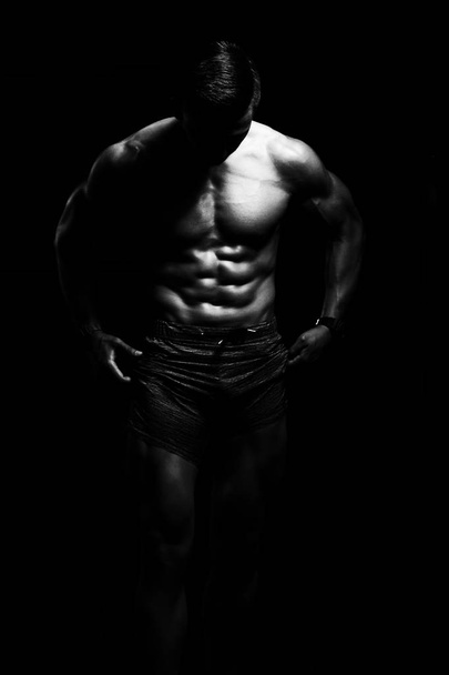 Homem muscular flexionando músculos no ginásio
 - Foto, Imagem