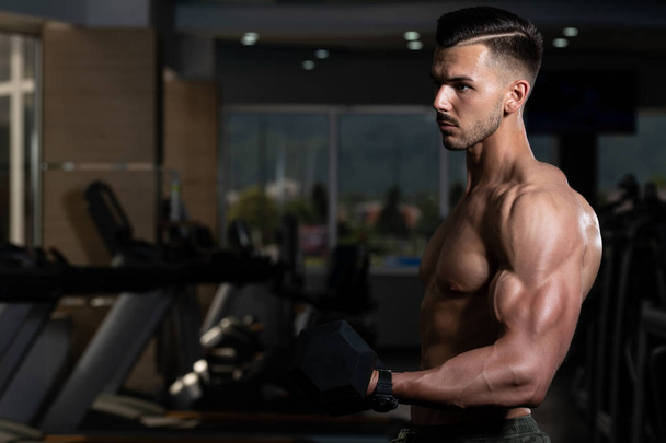 Muscular Man Exercising Biceps With Dumbbell - Photo, image