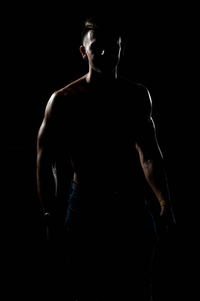 Siluet Muscular Bodybuilder In Jeans Flexing Muscles - Foto, imagen