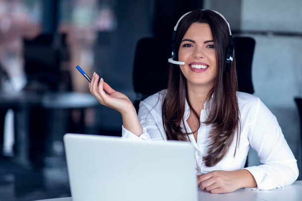 Portrait of happy smiling female customer support phone operator at workplace. - Fotoğraf, Görsel