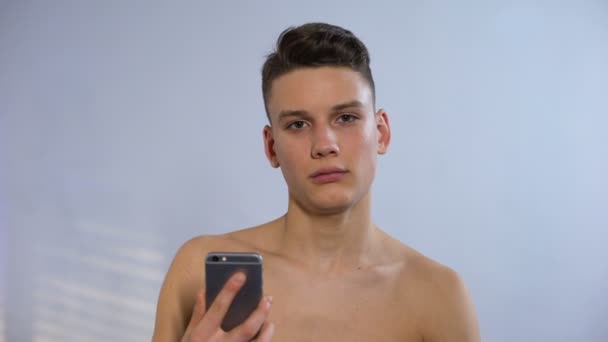 Funny teenager making selfie in bathroom, pretending to be self-confident, cool - Filmati, video