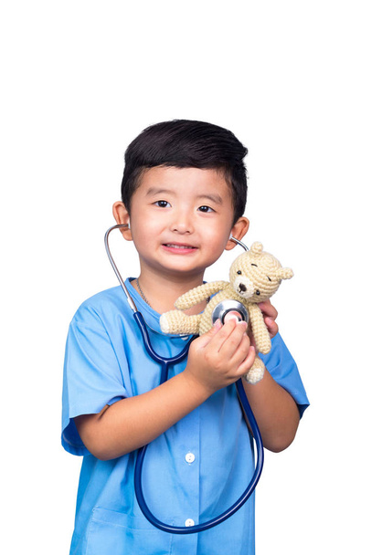 Χαμογελώντας Ασίας παιδί στο μπλε ιατρική στολή κρατώντας στηθοσκόπιο είναι - Φωτογραφία, εικόνα