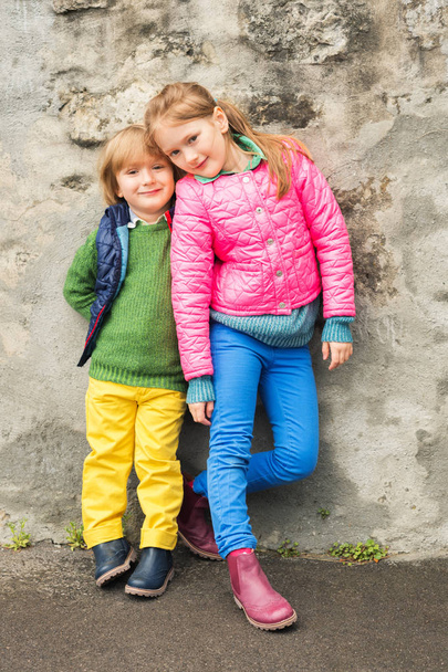 Outdoor portrait of two little kids, brother and sister, wearing colorful clothes - Zdjęcie, obraz