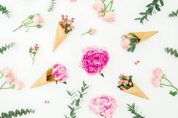 Floral pattern of pink peonies, roses petals, eucalyptus, waffle cones on white background. Flat lay - Photo, image