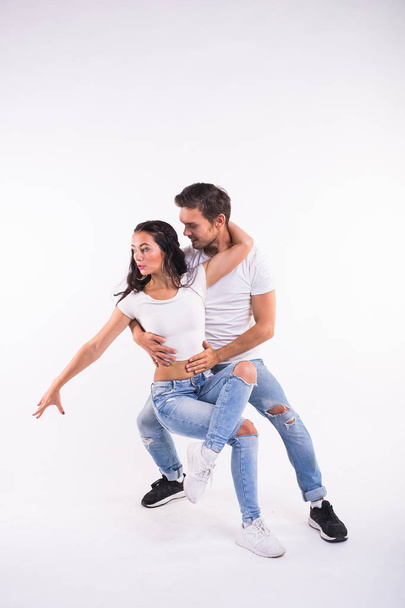 Vášnivý pár tančící sociální danse kizomba nebo bachaty nebo semba nebo taraxia na bílém pozadí - Fotografie, Obrázek