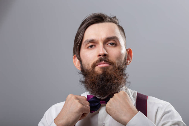 Menschen, Mode und Stilkonzept - Nahaufnahme Porträt junger stilvoller männlicher Hipster auf grauem Hintergrund - Foto, Bild