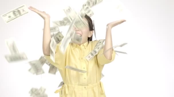 Zeitlupe einer jungen schönen asiatischen Frau mit Sommerkleid, die sehr aufgeregt aussieht, als ein Haufen Bargeld auf sie fällt, mit weißem Hintergrund, sehr glücklichem Gesicht. Urlaubs-Lifestyle-Konzept. - Filmmaterial, Video