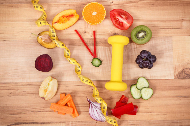 Свежие фрукты с овощами, гантели и сантиметр. Концепция здорового спортивного образа жизни
 - Фото, изображение