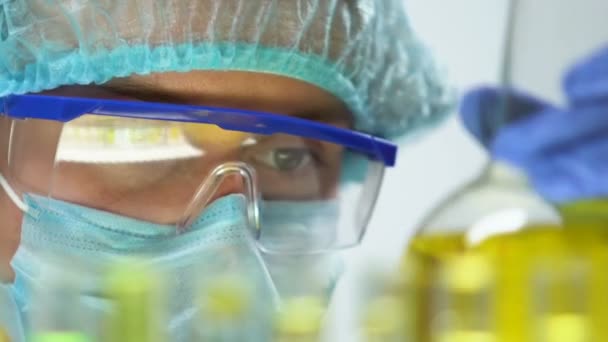 Lab worker marking flask with urine liquid, health and disease research, analyze - Video, Çekim