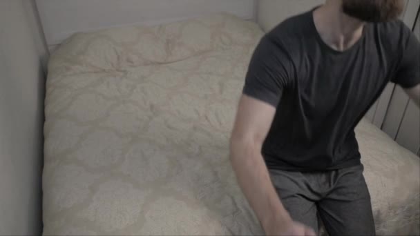 Bearded man falling on bed in slow motion - Footage, Video