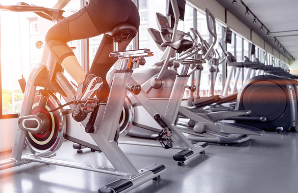 Exercise bike cardio workout at fitness gym of woman taking weight loss with machine aerobic for slim and firm healthy in the morning. - Photo, image