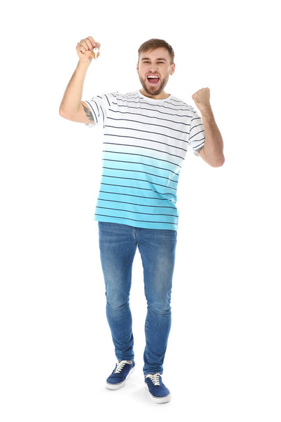Happy young man with house key on white background - Foto, Bild