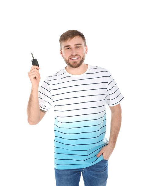 Happy young man with car key on white background. Getting driving license - Foto, Bild