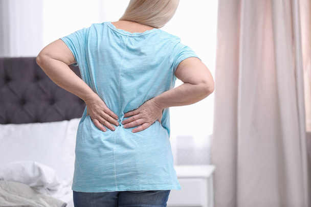 Senior woman suffering from back pain at home, closeup - Fotoğraf, Görsel