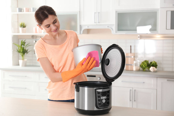 Woman cleaning modern multi cooker at table in kitchen - Foto, immagini