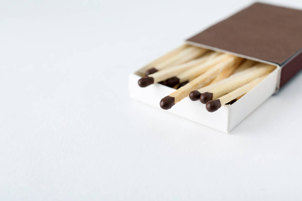 Cardboard box with matches on light background - Φωτογραφία, εικόνα