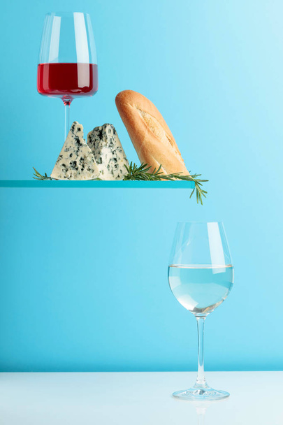 Blue cheese with bread, wine and rosemary on a blue background. - Photo, Image