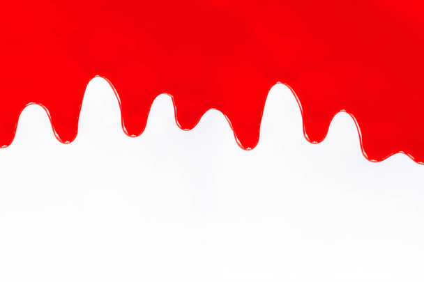 Rode verf druipend op een wit.  - Foto, afbeelding