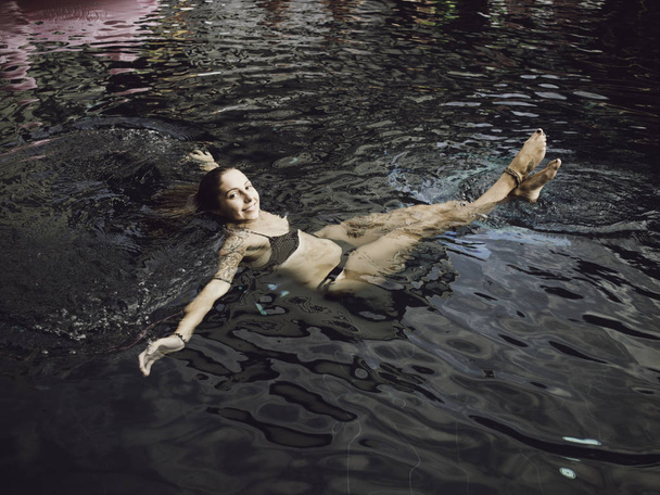 Genç kadın Suimming havuzunda rahatlatıcı bir yaz günü gökkuşağı ile - Fotoğraf, Görsel