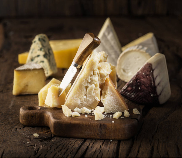 Piece of Parmesan cheese  on the wooden board. Assortment of dif - Fotoğraf, Görsel
