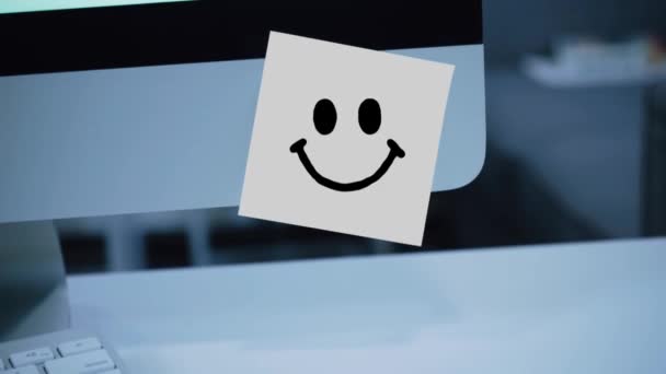 Smile character. Smile drawing on sticker on monitor. Message. Motivation. Reminder. Handwritten text written with a marker. Color sticker. A message for an employee, a colleague - Footage, Video