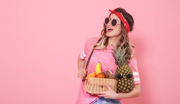 Portrait of a girl with healthy food, fruits, on a pink backgrou - Фото, зображення