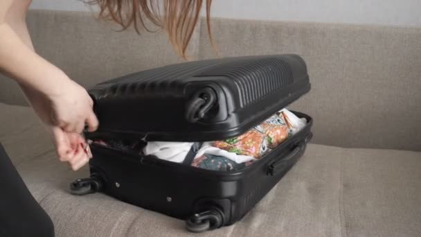 lány véletlenül csomagolás, és megpróbálja bezárni a zsúfolt bőrönd. - Felvétel, videó