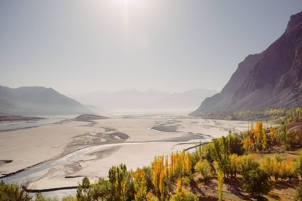 Widok z lotu ptaka krajobraz rzeki Indus przepływający przez Katpana zimnej pustyni w Skardu z gór Mglistych w tle. Pięknych liści w sezonie jesiennym. Gilgit Baltistan, Pakistan. - Zdjęcie, obraz