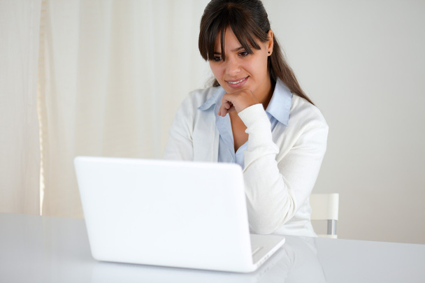 Pensive young female reading on laptop screen - Fotó, kép
