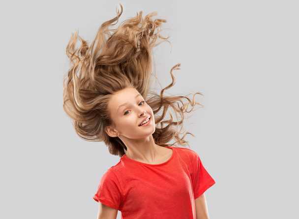 menina adolescente sorridente em vermelho com cabelo ondulado longo
 - Foto, Imagem
