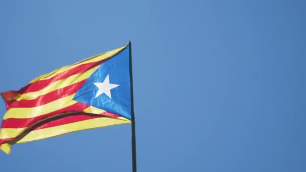 Una bandera de la República de Cataluña ondea debido a un fuerte viento. Los colores de la bandera de independencia no oficial son rojo, amarillo y azul, con una estrella blanca en el centro
. - Metraje, vídeo