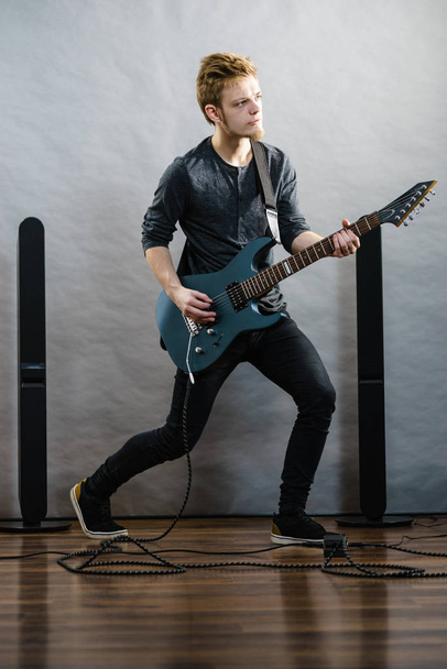 Young man playing electric guitar - Foto, afbeelding