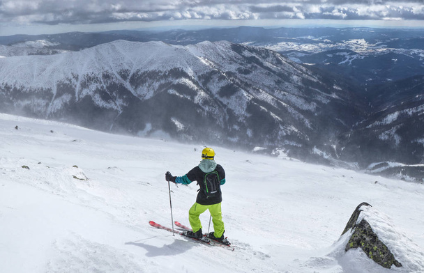 Szerelmes a ski-Alacsony-Tátra legjobb időjárás vár. A kilátás a freeride. Egy férfi síelőnek állandó hegy tetején, és kiválasztja a legjobb pálya. Sárga bukósisak, fekete hátizsák - Fotó, kép