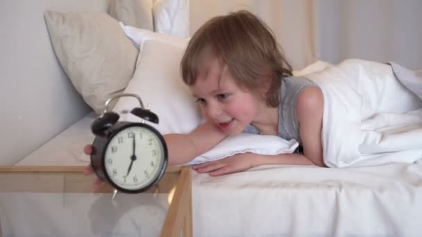 Sweet kid sleeping with alarm clock near his head. - Imágenes, Vídeo