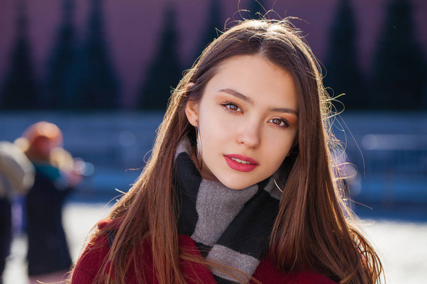 Young beautiful brunette woman in red coat posing on winter park - Foto, afbeelding